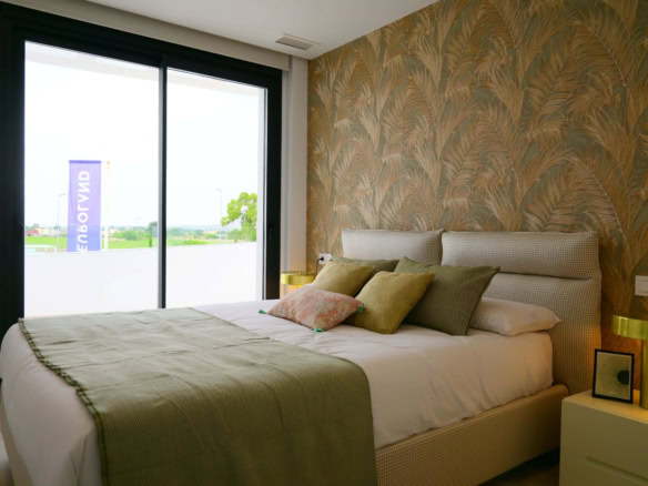 Ruime slaapkamer met grote glaswand, uitzicht op tuin, trendy interieur, comfortabele bed, stijlvolle decoratie.