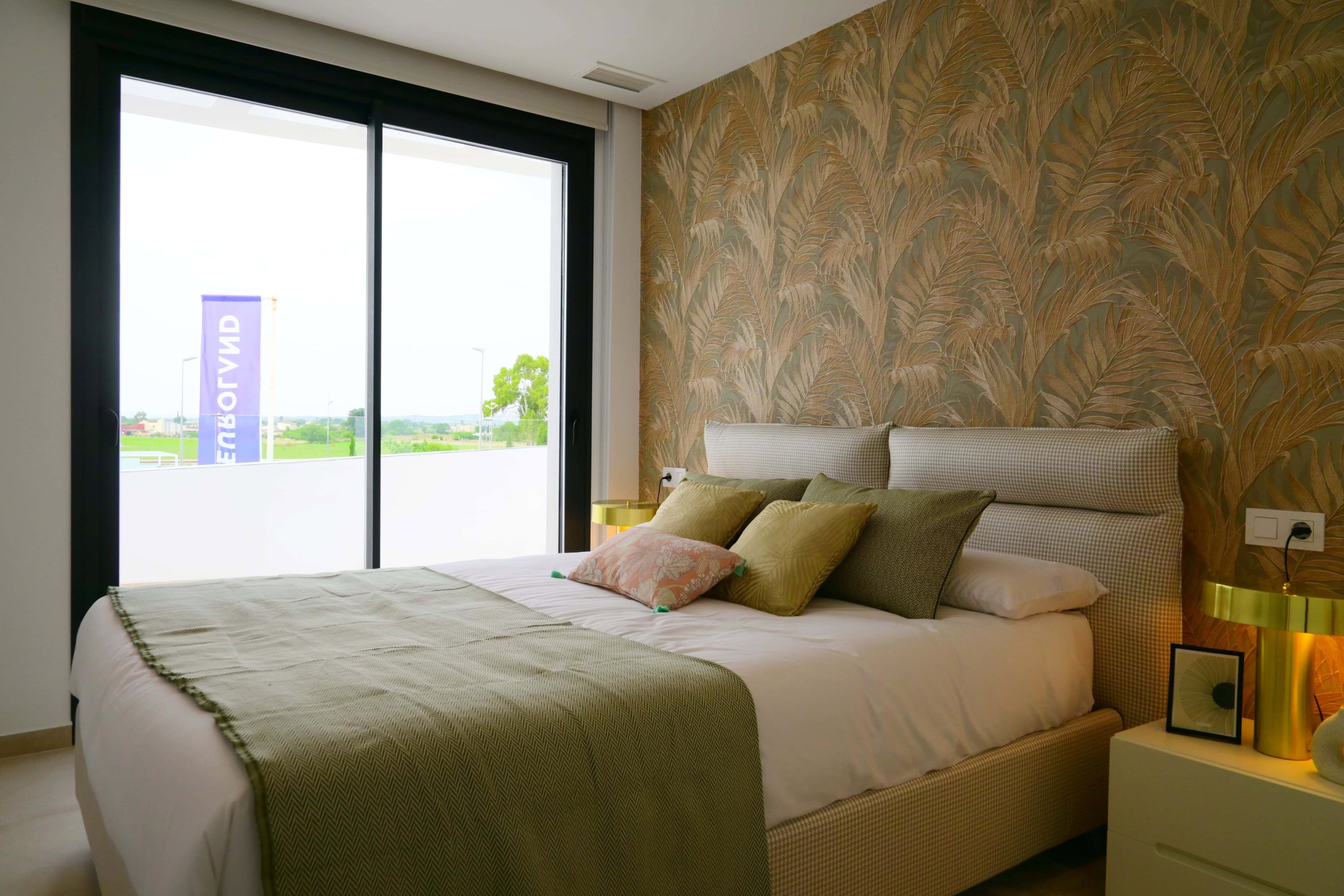 Ruime slaapkamer met grote glaswand, uitzicht op tuin, trendy interieur, comfortabele bed, stijlvolle decoratie.