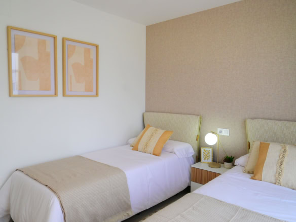 Alt tekst: Tweepersoonskamer met 2 bedden, sfeervolle verlichting en moderne decoratie, ideaal voor gasten of bewoners.