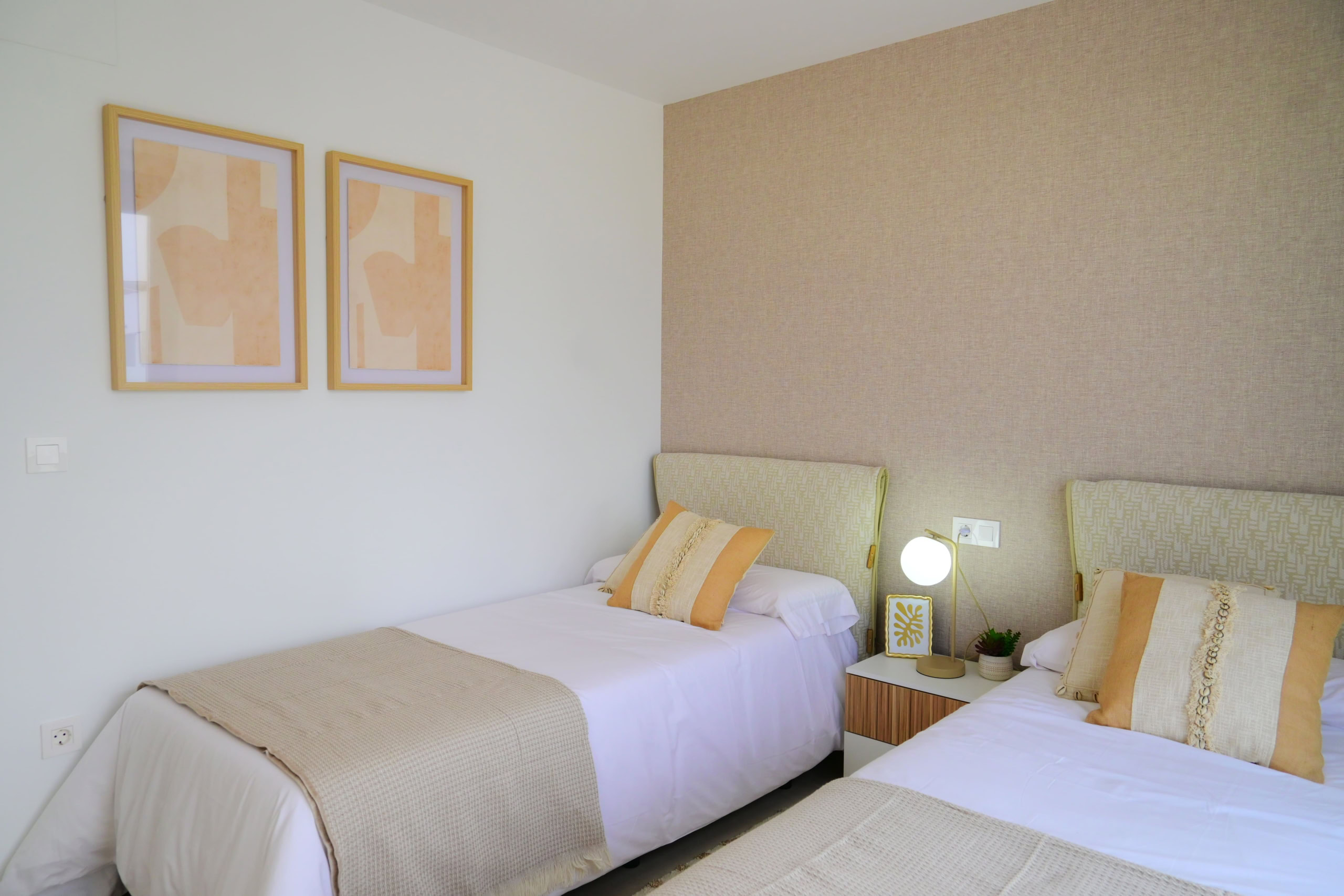 Alt tekst: Tweepersoonskamer met 2 bedden, sfeervolle verlichting en moderne decoratie, ideaal voor gasten of bewoners.