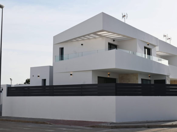 Moderne witte woning met ruime balkon en glazen balustrades, gelegen in rustige buurt.