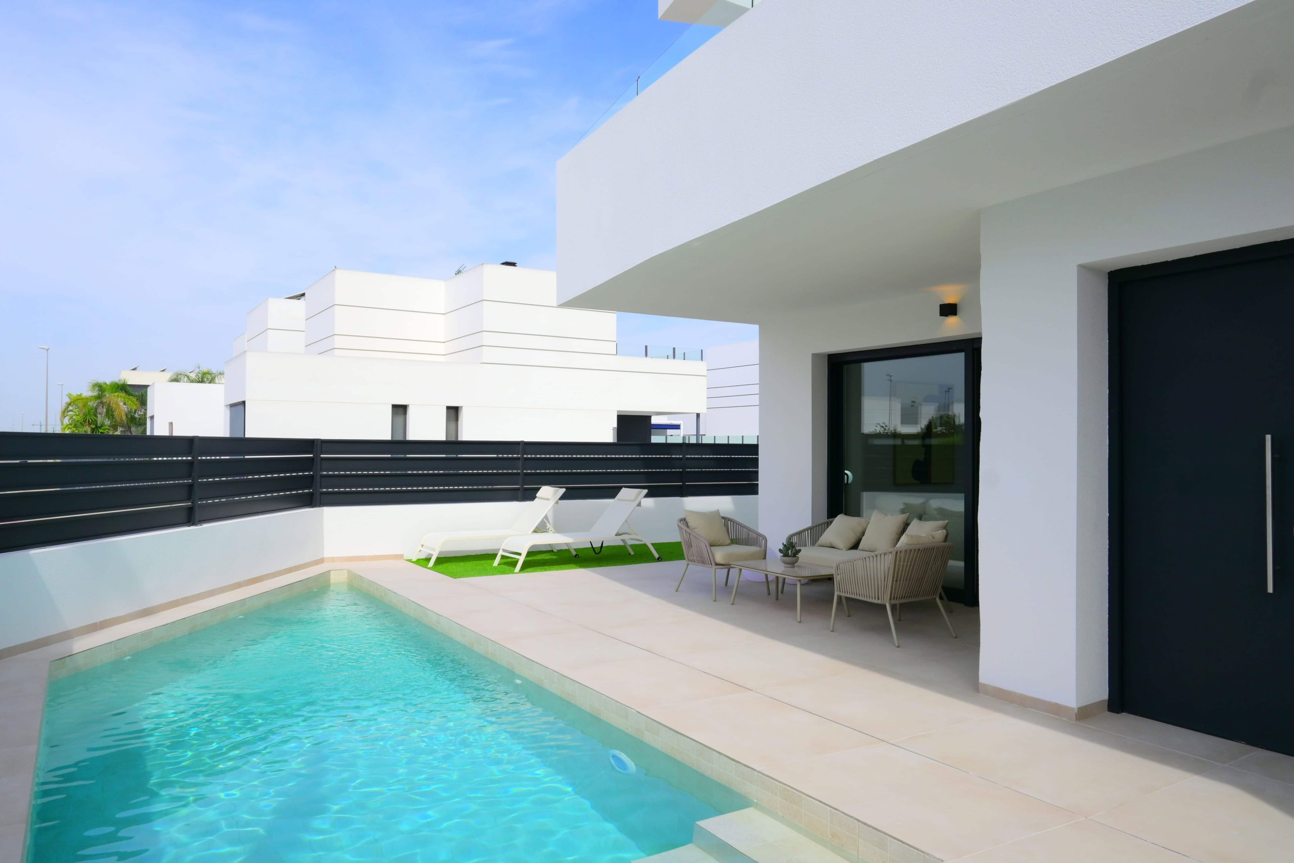 Luxe flat met privézwembad, modern ontwerp, terras met loungestoelen en comfortabele buitenmeubels.