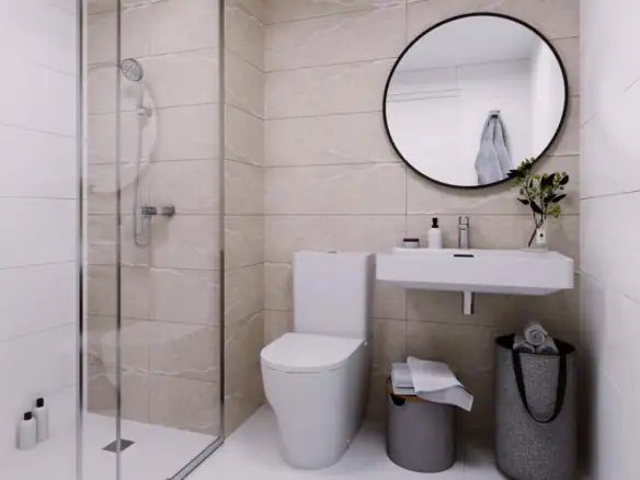 Moderne badkamer met douche, toilet en ronde spiegel in een lichte, strakke ruimte.