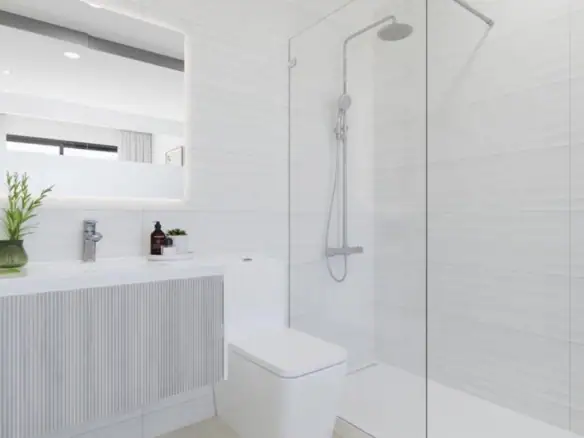 Moderne badkamer met douche, toilet en spiegel in lichte kleuren.