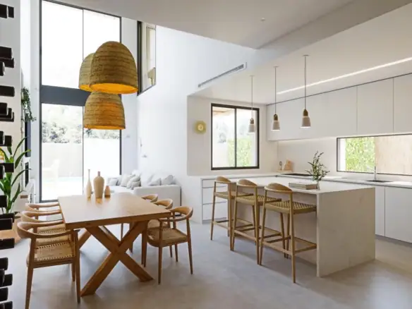 Moderne keuken en eetruimte in luxe villa met grote ramen en natuurlijke lichtinval.