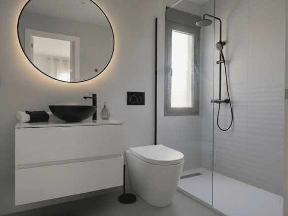 Moderne badkamer met inloopdouche, wandspiegel en wit sanitair.