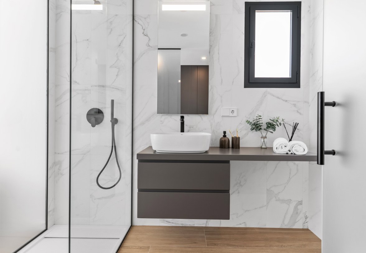 Moderne badkamer met marmeren wanden, inloopdouche en wastafel in Cumbre del Sol.