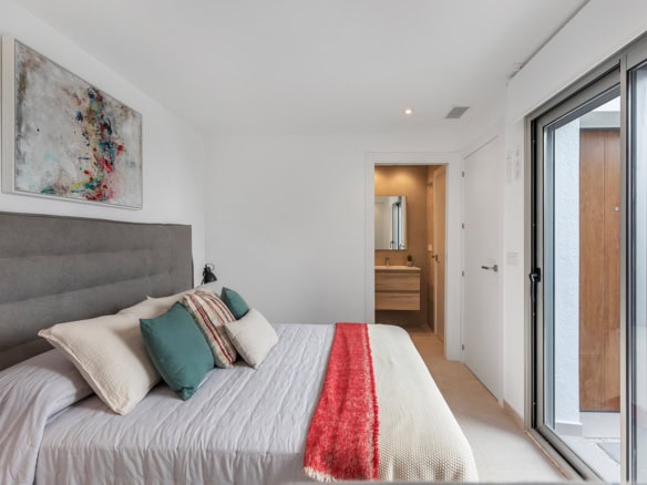 Ruime slaapkamer met balkon en uitzicht op patio.
