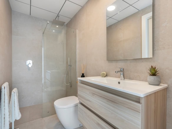 Moderne badkamer met inloopdouche, toilet en wastafel in een nieuwbouwappartement.