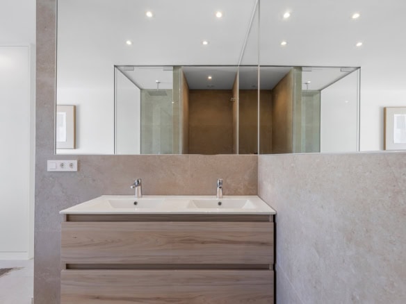 Moderne badkamer met dubbele wastafel en grote spiegel, strak design en neutrale kleuren.