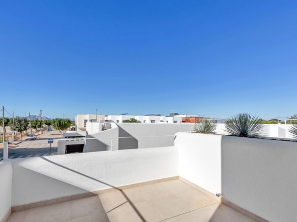 Ruim balkon met wit Ibiza-stijl design en uitzicht op de blauwe hemel.