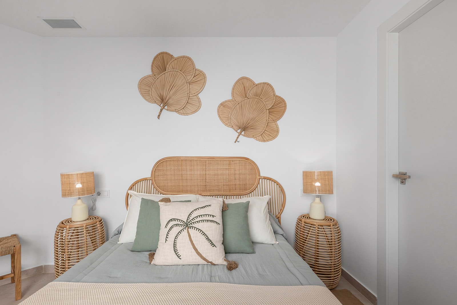 Zonnetje in Huis Makelaardij – Ibiza-stijl slaapkamer Zonnetje in Huis Makelaardij: Ibiza-stijl slaapkamer met rieten decoratie en natuurlijke kleuren.