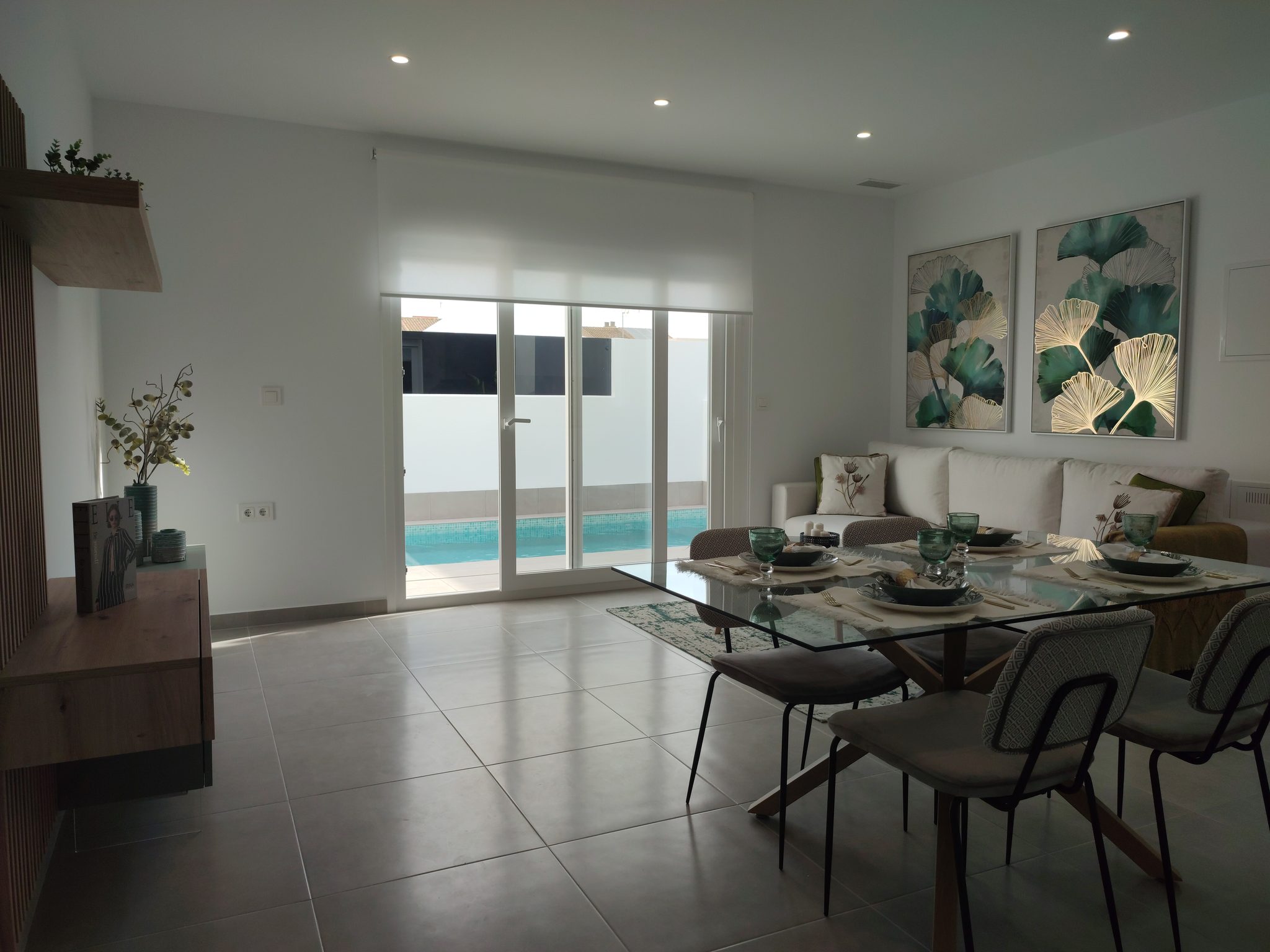 Moderne woonkamer met uitzicht op zwembad Ruime woonkamer met grote glazen deuren naar zwembad in nieuwbouw villa.