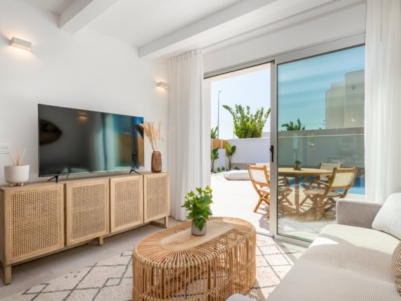 Ruime woonkamer met uitzicht op balkon en buitenruimte.