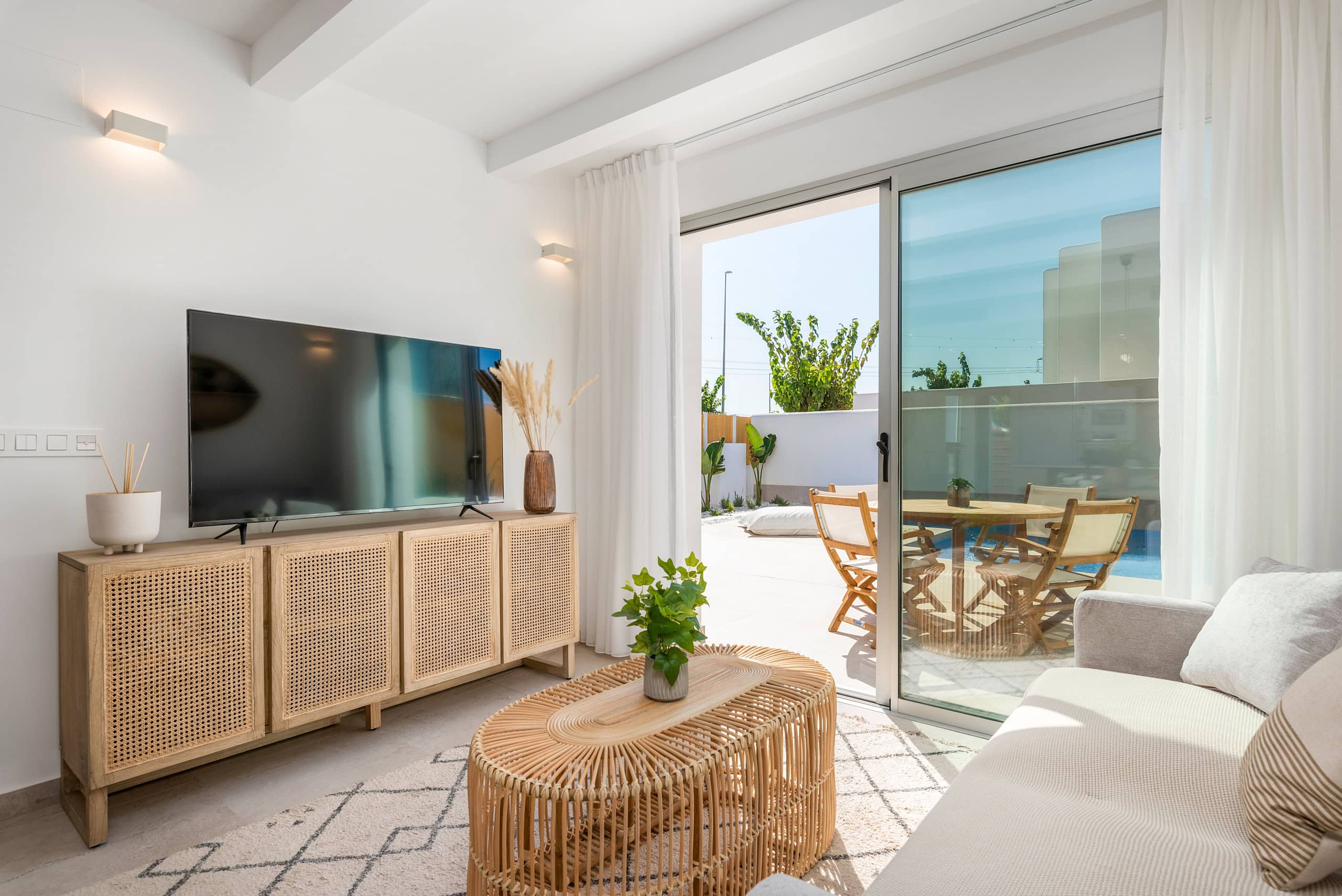 Zonnetje in Huis Makelaardij – Ibiza-stijl appartement Ruime woonkamer met uitzicht op balkon en buitenruimte.