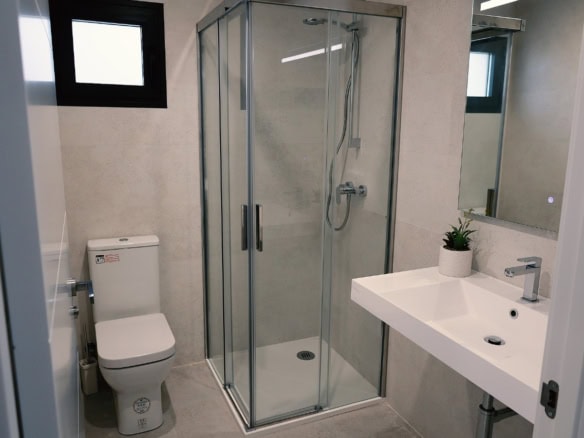 Moderne badkamer met douche, toilet en wastafel in nieuwbouwwoning in Fuente Álamo.