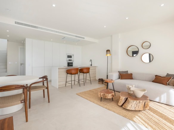 Moderne, lichte woonkamer met open keuken en comfortabele zithoek in villa aan Serena Golf.